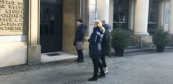 Tre mennesker fra projektet foran bygning