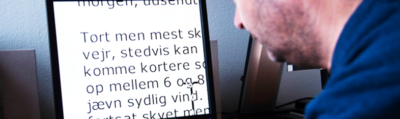 Man sidder foran skærm, der bruger forstørrelse