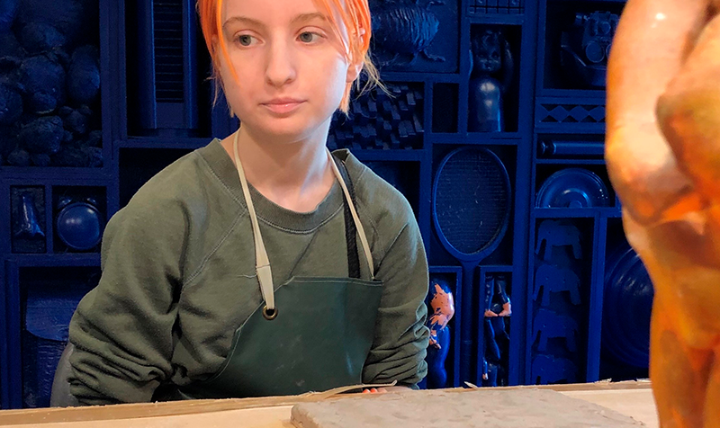 Ung kunster sidder med ler