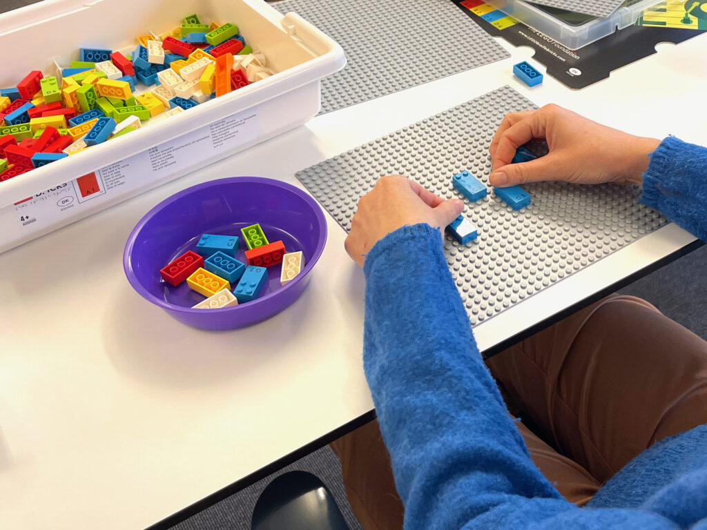 Hænder føler på LEGO Braille-klodser