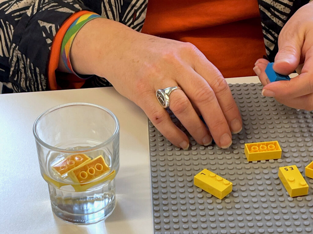 Glas vand med to legoklodser i