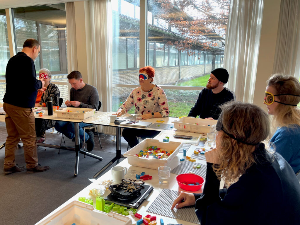 Workshopdeltagerne sidder med legoplader klar til at lave en øvelse