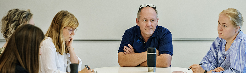 Foto af 4 personer rundt et mødebord.