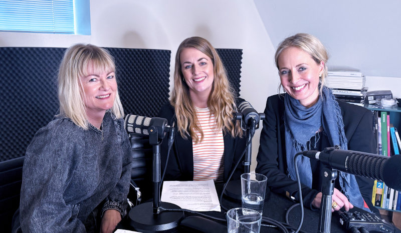 IBOS's ergoterapeuter Lone Bøgeskov og Mette Murmann Frosberg sidder sammen med podcastvært Line Friis Frederiksen ved et bord med mikrofoner.