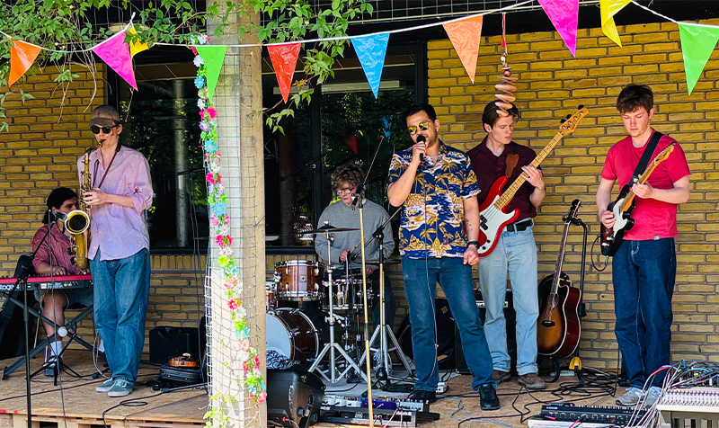 Bandet UTAL med seks personer står på scenen og spiller koncert.