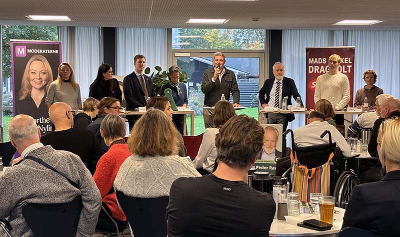 Foto af panelet, der står på række foran publikum klar til at tage i mod spørgsmål