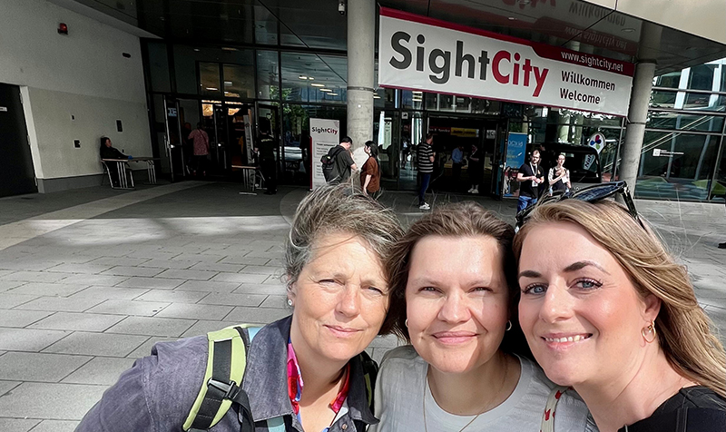 3 personer fra IBOS står ude foran skiltet med Sight City